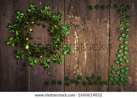 St. Patricks Day composition. Shamrock wreath, shamrocks on an old rustic wood background. St.Patrick's day holiday symbol. Top view, copy space.