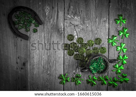 St. Patricks Day composition. Shamrocks, horseshoe, coins and silver pot on vintage style wood background. St.Patrick's day holiday symbol. Top view, copy space.