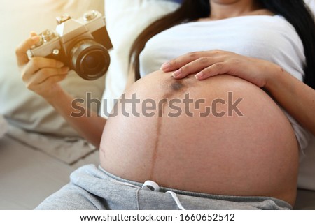 mother using film camera take a photo of pregnancy the memories with beautiful love