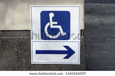 The International Symbol of Access - wheelchair symbol with right arrow direction sign in the street.