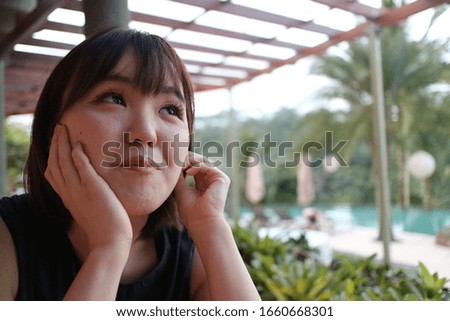 A beautiful lady relaxing at a poolside restaurant.