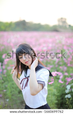 Portrait of Japanese school girl uniform with pink cosmos flower 