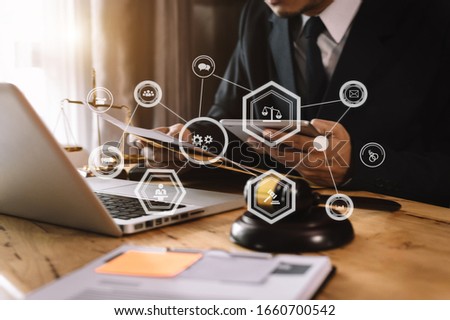 justice and law concept.Male judge in a courtroom  the gavel, working with smart phone and laptop and digital tablet computer on wood table with VR icon