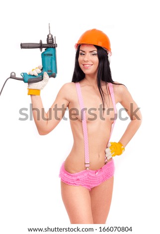 Brunette in pink panties with suspenders in the construction helmet with an electric drill on a white background.