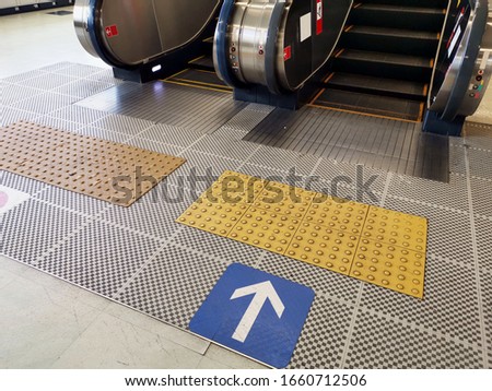 Touch floors for disabled people, tile walkways is used for walking up the escalator. 