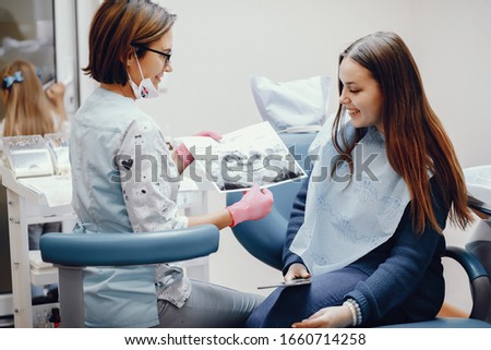 Girl talking to the dendist. Beautiful lady in the dentist's office. Woman in a uniform