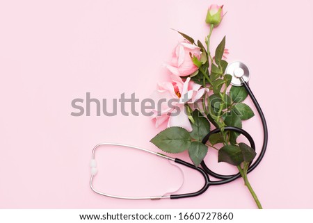 Bunch of rose flowers and stethoscope on pink background. National Doctor's day. Happy nurse day. Top view with copy space Royalty-Free Stock Photo #1660727860