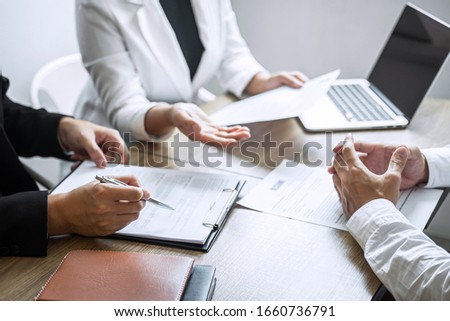 Employer or committee holding reading a resume with talking during about his profile of candidate, employer in suit is conducting a job interview, manager resource employment and recruitment concept. Royalty-Free Stock Photo #1660736791