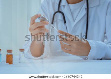 The hand  holding syringe against white medical 