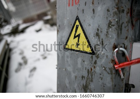 old rusty yellow electrical panel with hazard symbol