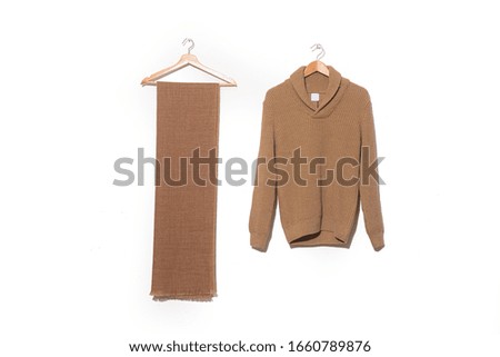 Knitted sweater. Warm winter brown wool 
 sweater with brown scarf on hanging 
	

