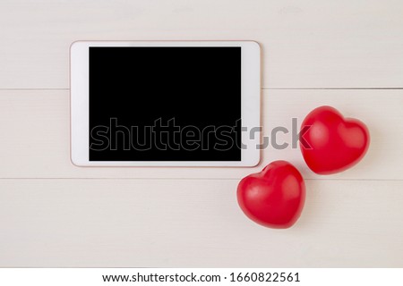 Happy mother day or valentine day with symbol heart shape and tablet display on wooden table, feeling romantic and care with decoration, present festive with on desk, top view, holiday concept.