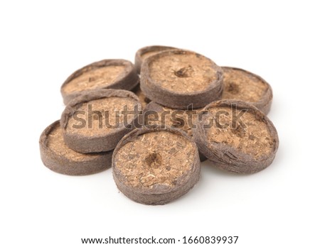 Pile of seed starting peat pellets isolated on white Royalty-Free Stock Photo #1660839937