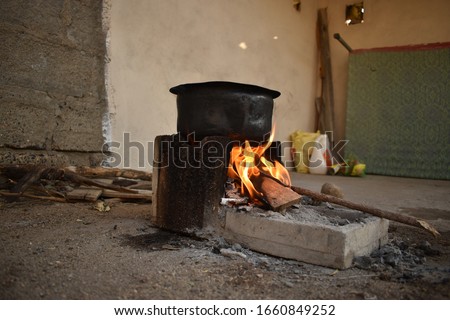 Boiling water with old traditional Indian cooking stove (chulha) Hindi name  In small Indian village 