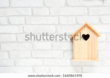 Top view nature wooden house model on white brick wall background.  easter, buisness, loan and finance concept.