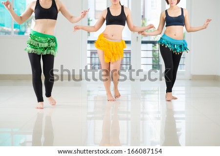 Belly dancers shaking their hips while performing in the dance hall Royalty-Free Stock Photo #166087154