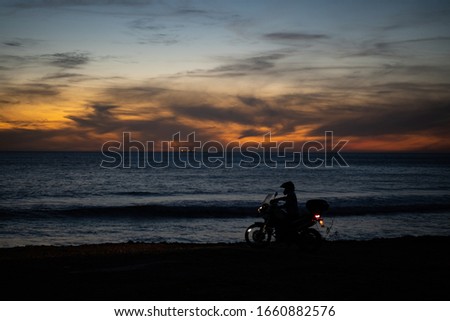 Motorcyclist off the beaten track close to the infamous surfspot Anchor Point, riding along beach of the ocean. 