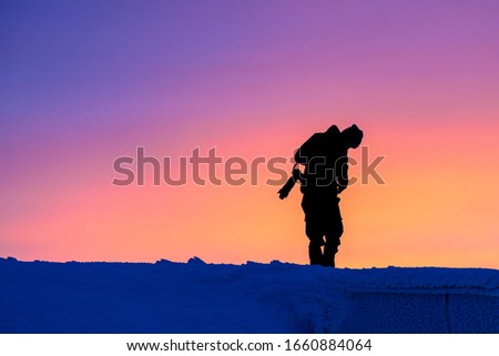 Photographer silhouette. Golden hour in snowy mountains, Kronplatz, Italy. It is a mountain of the Dolomites in South Tyrol, with a summit elevation of 2,275 metres (7,464 ft) above sea level