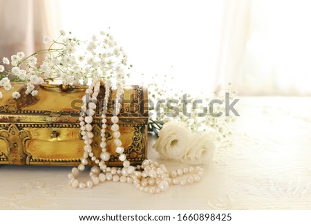 Vintage antique jewellery box and pearls necklace. Wedding concept. Back light
