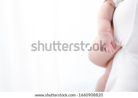 Closeup picture of a baby's hand while baby are sleeping in white bright curtain. New born baby, motherhood, mom and kids and children concept.