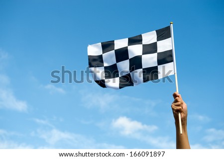 checkered race flag in hand. Royalty-Free Stock Photo #166091897