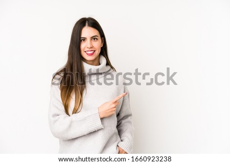 Young caucasian woman isolated on a white background smiling and pointing aside, showing something at blank space.