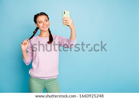 Photo of beautiful lady hold telephone hand making funny selfies online blog translation video call wear casual pink sweater green trousers isolated blue color background