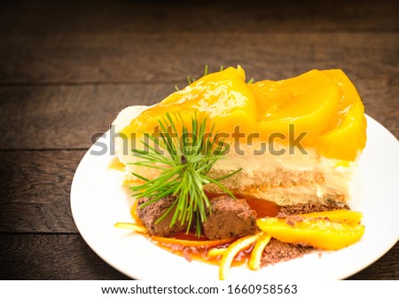 Peach cheesecake, creamy peach cake topped with jelly and truffle on plate closeup