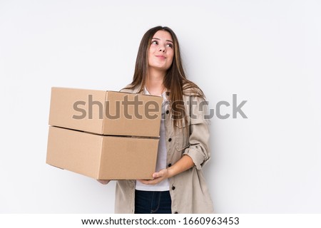 Young caucasian woman moving to a new home dreaming of achieving goals and purposes