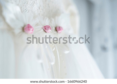 Close-up of white lace dress with beautiful floral motifs and thin textile material for newborn girls. An image that expresses purity and innocence on the day of baptism.