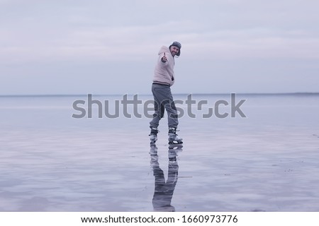 one guy skates on the ice of a frozen lake, nature landscape, man outdoor sports