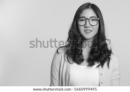 Portrait of young beautiful Asian woman in black and white
