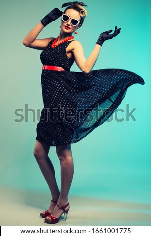 Young beautiful woman in retro pin-up style with fluttering dress.