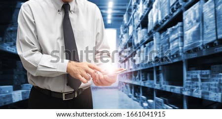Businessman is standing at office of warehouse, he is planning management smart logistic concept