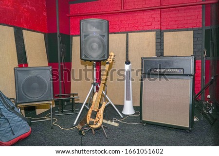 View of the rehearsal room, speakers, and bass guitar