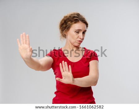 Emotional woman gesturing with hands discontent refusal gray background