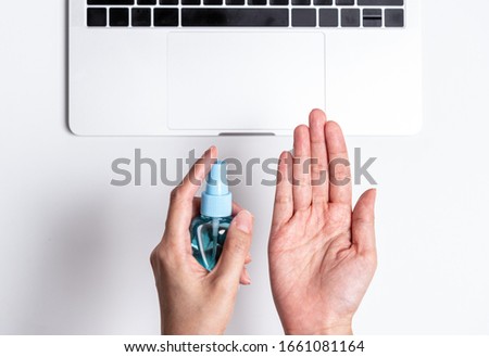 The employee has cleaning hand with hand cleaner gel before start to working with laptop in the office
