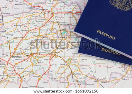 Pieces of two blue passports close-up on a atlas