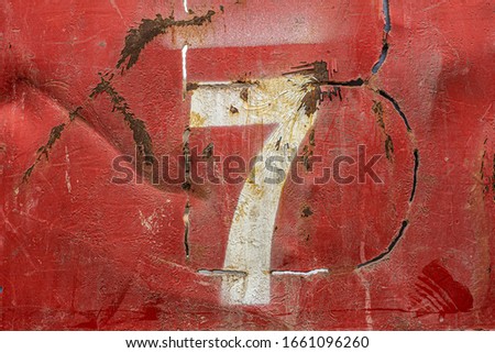 Number seven 7 on an old rusty metal background. Texture of old paint and rust on the numbers.