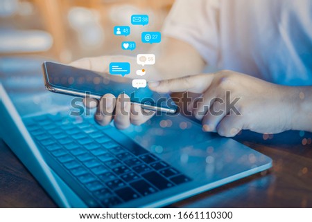 Person using a social media marketing concept on mobile phone with notification icons of like, message, comment and star above mobile phone screen. Royalty-Free Stock Photo #1661110300