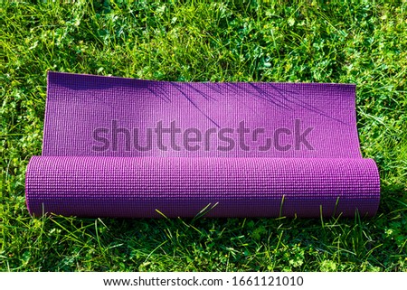 High angle view of Yoga mat on green grass , close up