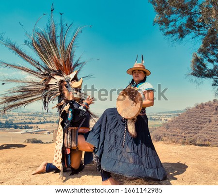Mexican dancers posing at camera with tufts and pre-Hispanic dress