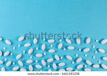 Medical background. White Pills pattern on blue background. Flat lay. Medicine concept. pharmaceuticals antibiotics pills medicine.