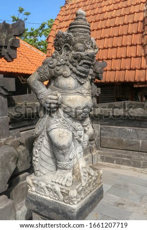 Closeup of stone statue in Temple Batu Bolong near to Tanah Lot in Bali, Indonesia. A carved statue with fine details that stands outside the entrance to Hindu temple as a guardian. Balinese culture.