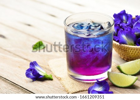 Butterfly pea or blue pea juice ice cool drink with lime on wooden table. Royalty-Free Stock Photo #1661209351