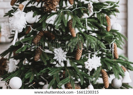 Christmas tree decorated with cones, toys, balls and white snowflakes. Photography, concept.