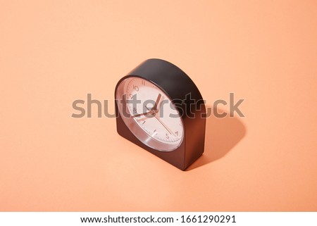 black clock on peach background with copy space