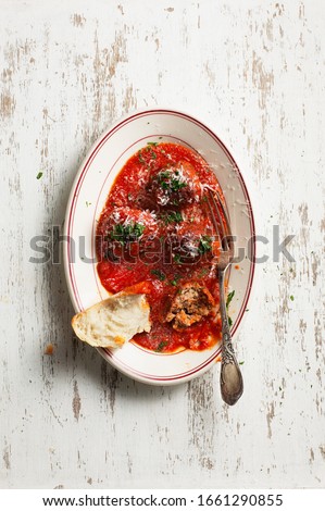 Meatballs and red tomato sauce with bread on wood background 