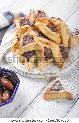 Traditional Jewish Hamantaschen cookies with  dried apricots, dates. Purim celebration concept. Сarnival holiday background. Selective focus. Copy space.
