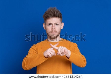 Attractive young guy with a yellow T-shirt on a blue background